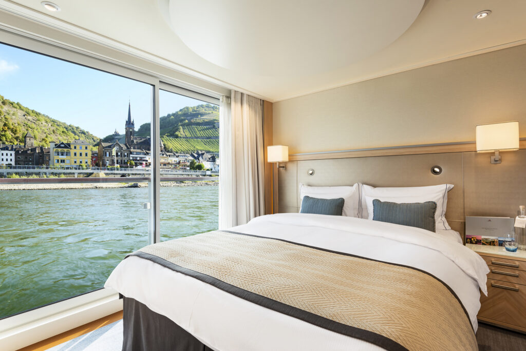 Veranda Suite bedroom on-board the Viking Longship Hlin.  The town of Lorch am Rhein of the Upper Middle Rhine Valley, Germany is seen outside the window.